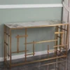 Consolle Nayumi stile Japandi con top in ceramica beige effetto marmo Calacatta e struttura in metallo dorato