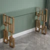 Consolle Sorika stile Japandi con top vetro trasparente e struttura in metallo dorato